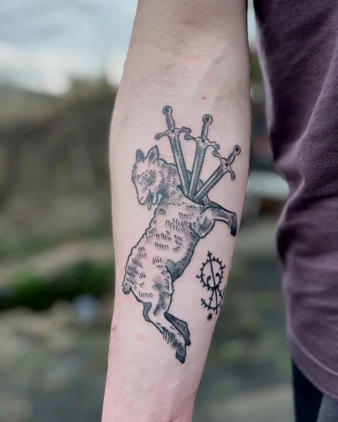 Artistic lamb tattoo with sword symbolism