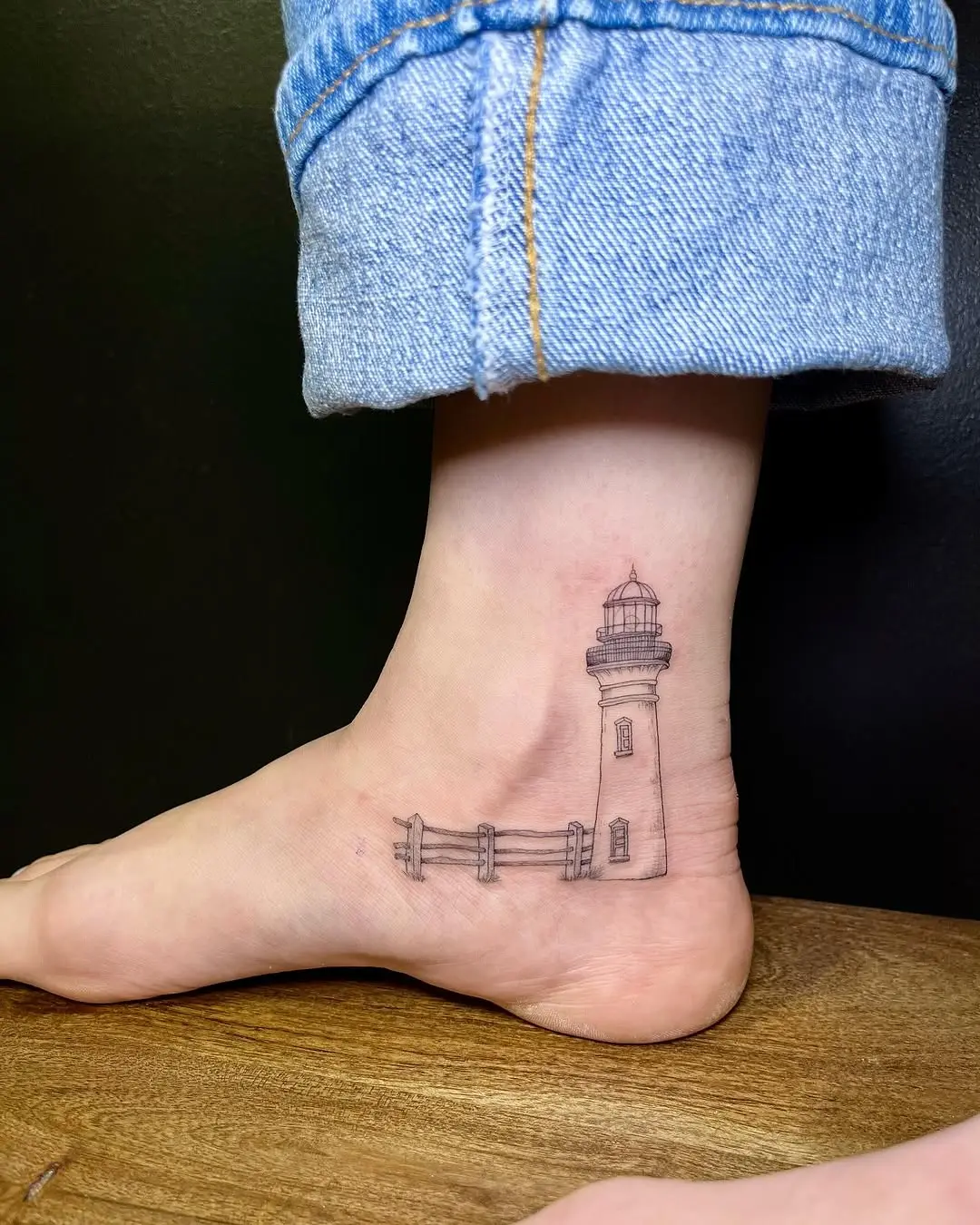 Stunning minimalist lighthouse ankle tattoo