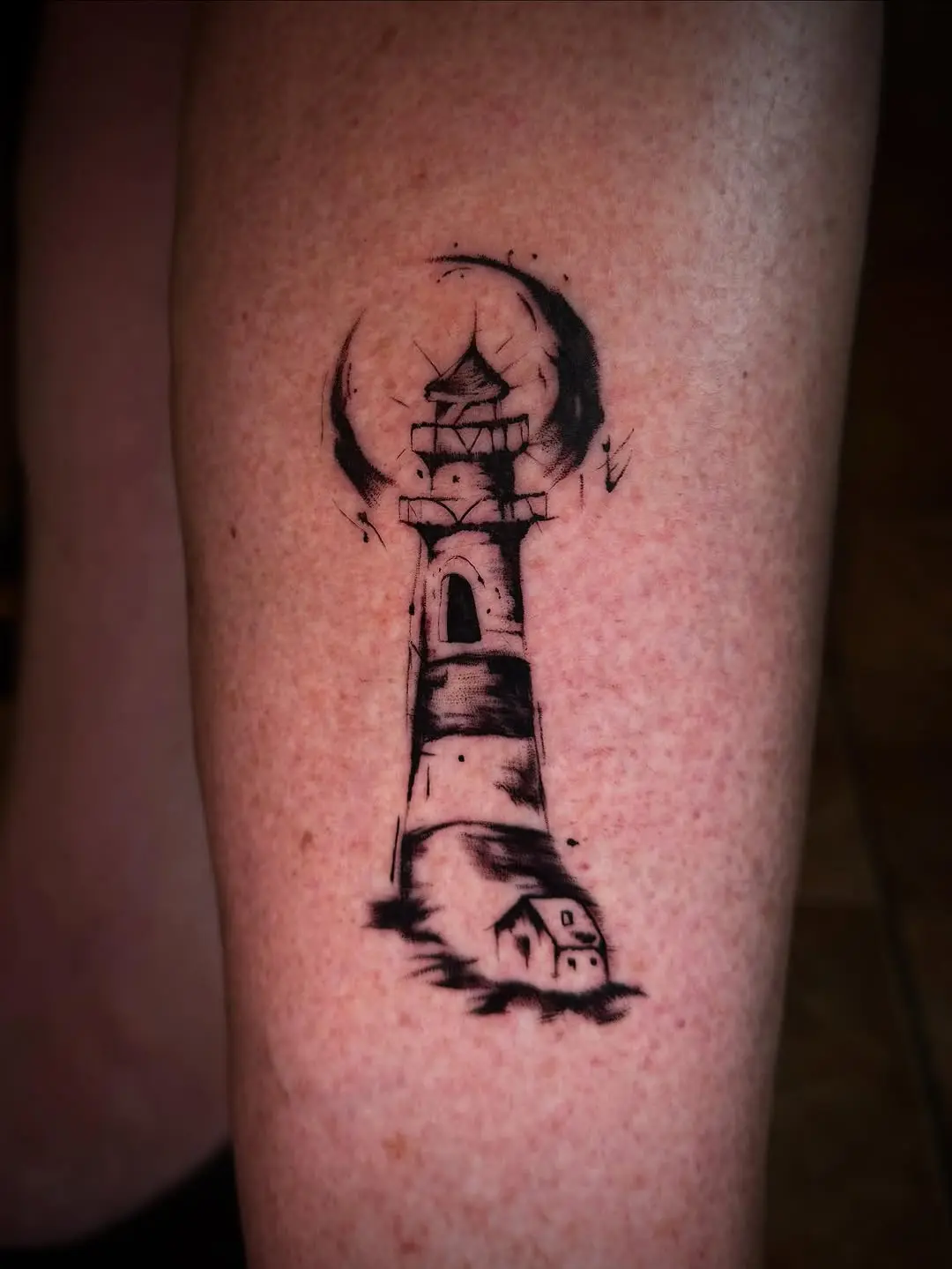 Stunning lighthouse tattoo with bold black ink