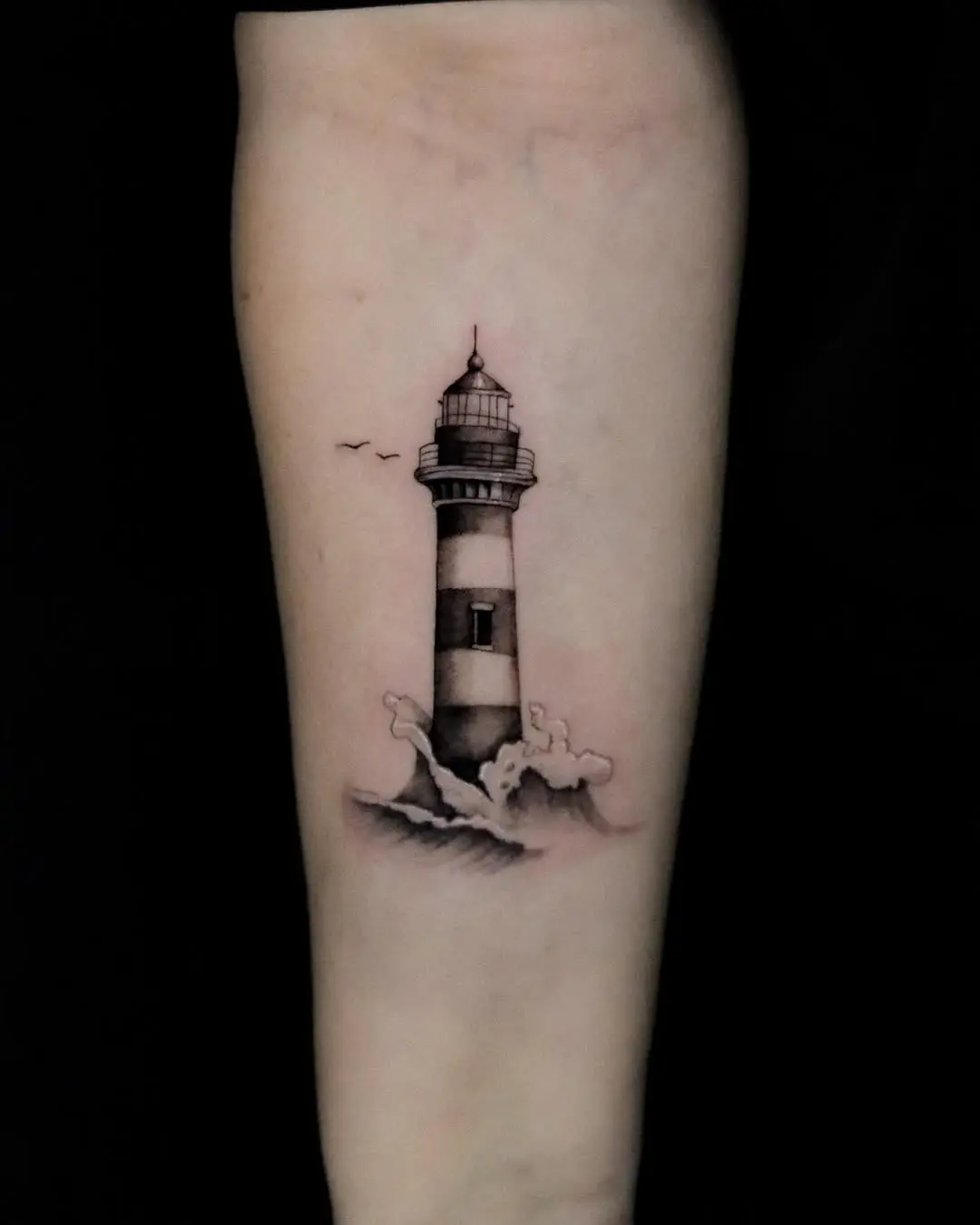 Elegant lighthouse tattoo with waves and birds