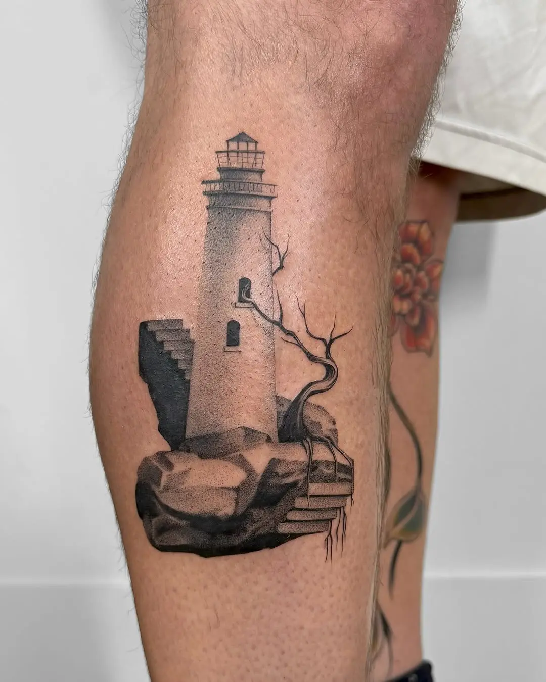 Intricate lighthouse tattoo on leg, showcasing artistry