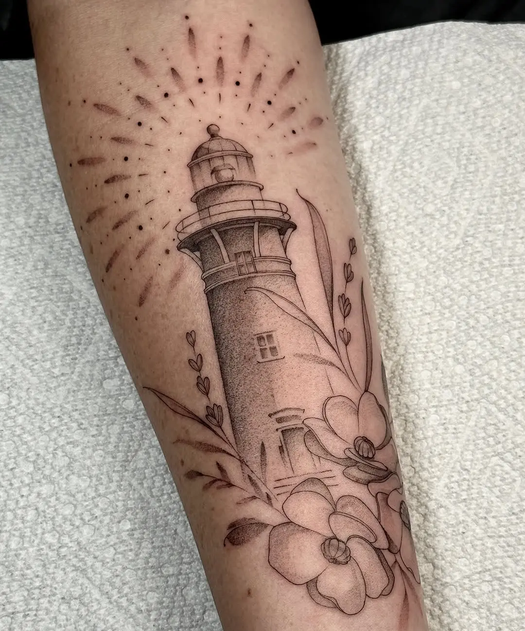 Elegant lighthouse inked with floral motifs