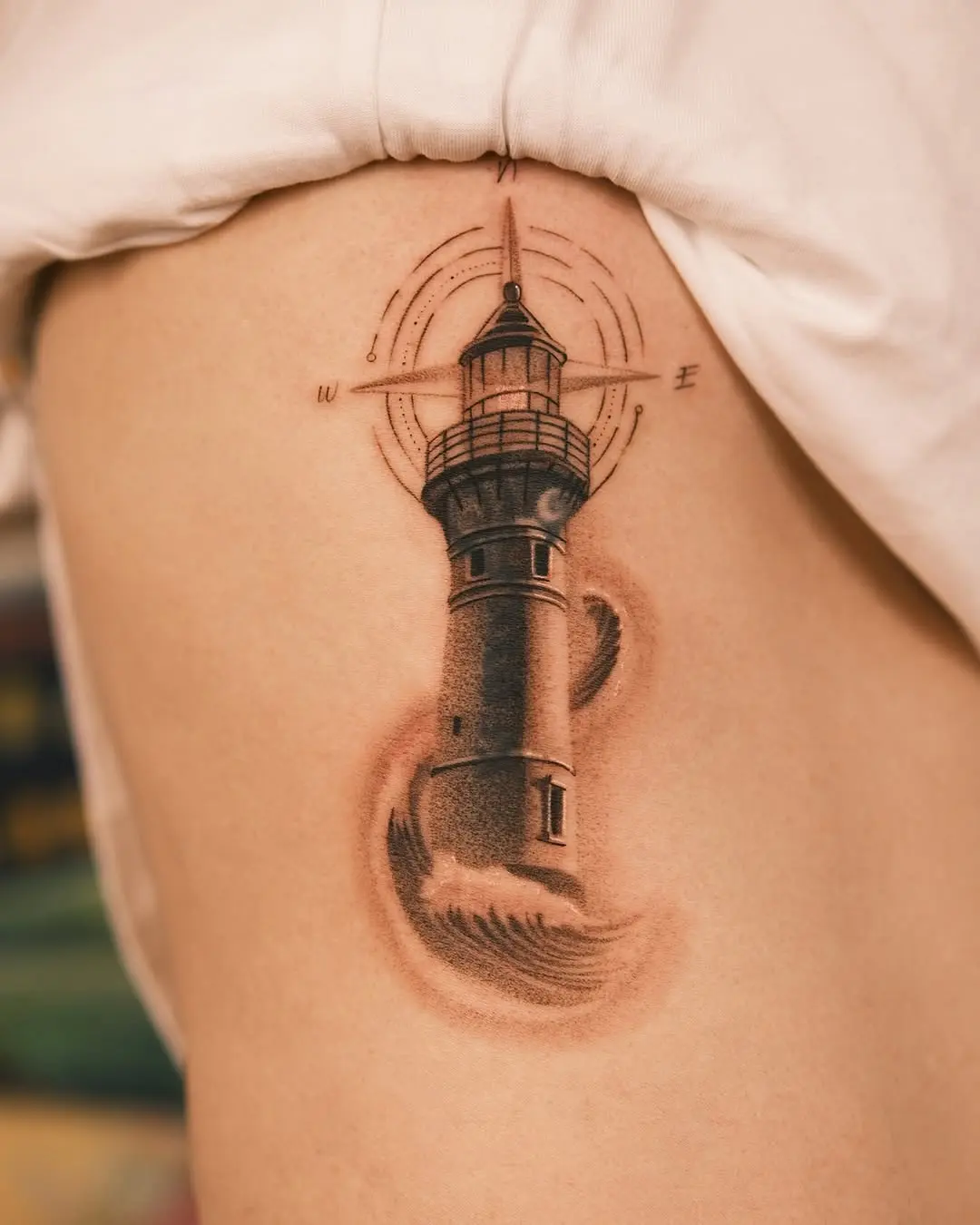 Nautical lighthouse tattoo with wave details
