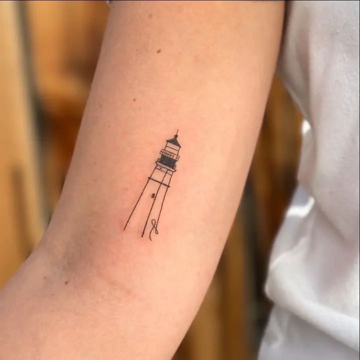 Elegant minimalistic lighthouse tattoo design
