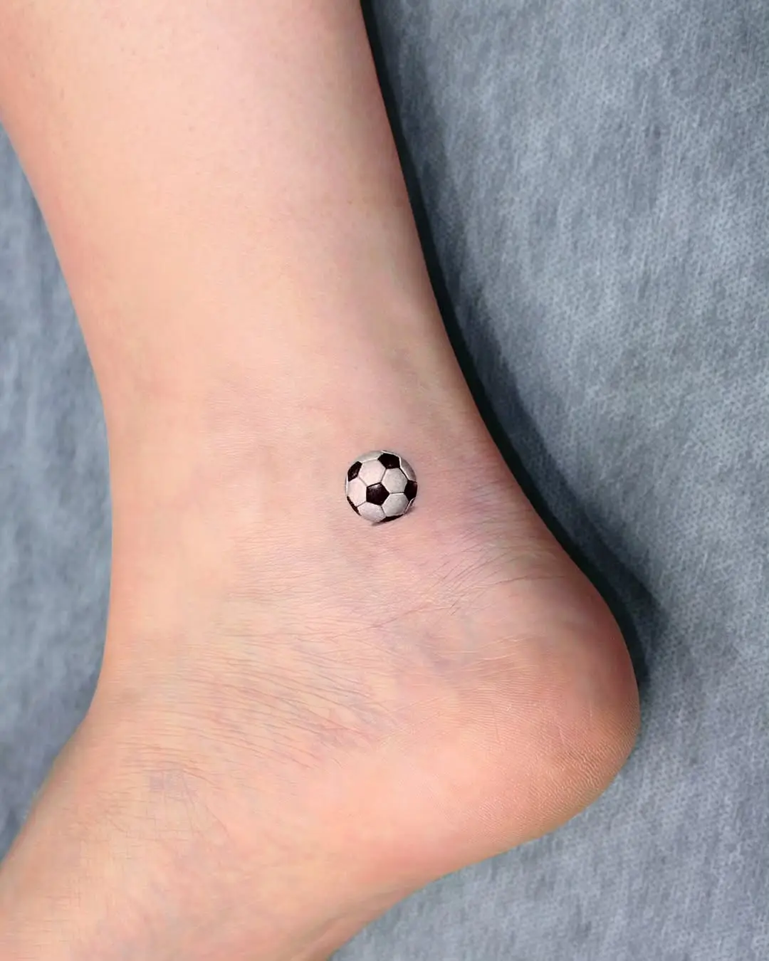 Stylish soccer tattoo on the ankle