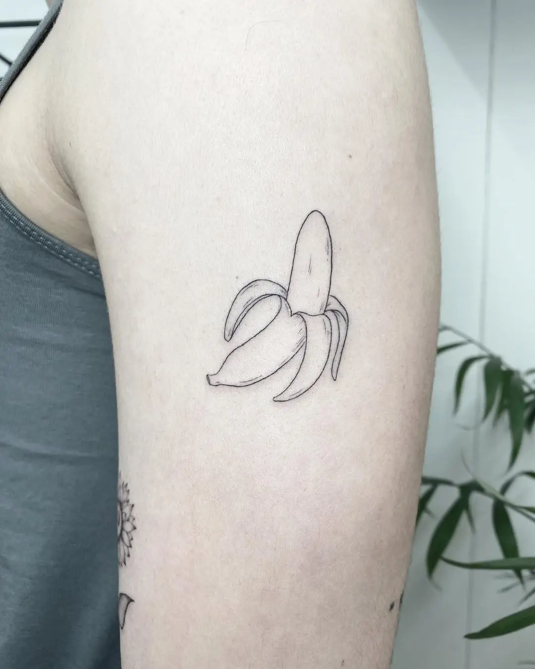 Charming minimalistic banana tattoo design