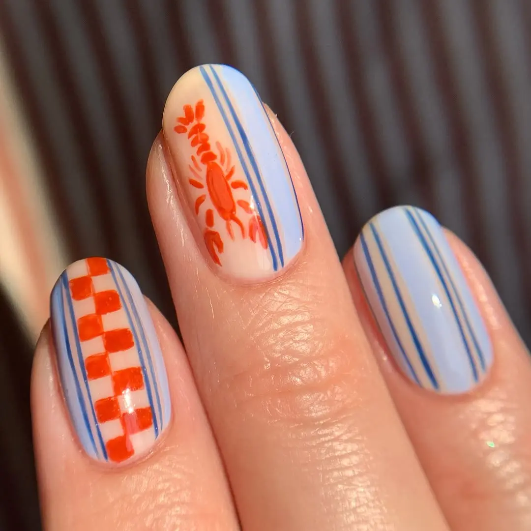 Stylish nails featuring crabs and blue stripes