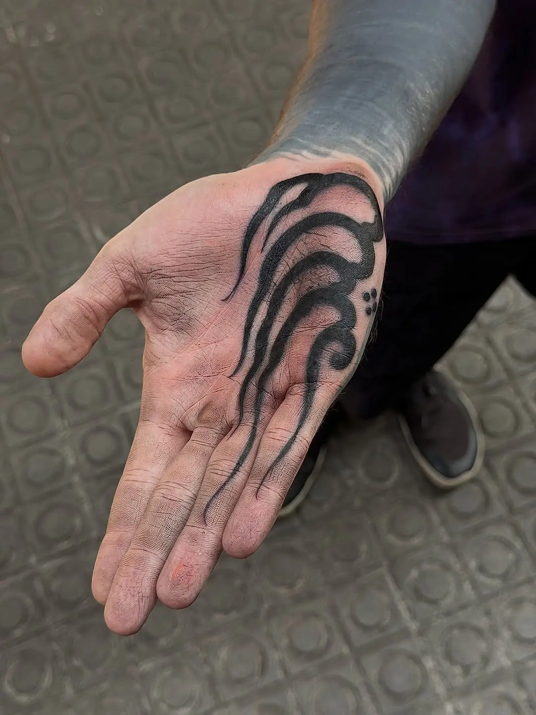 Intricate black ink palm tattoo design