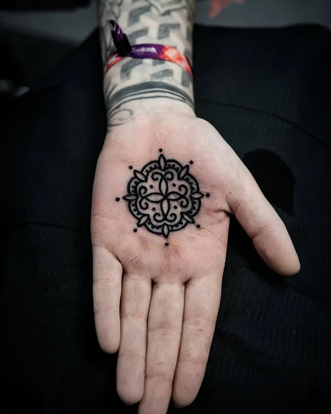 Intricate mandala palm tattoo in black ink