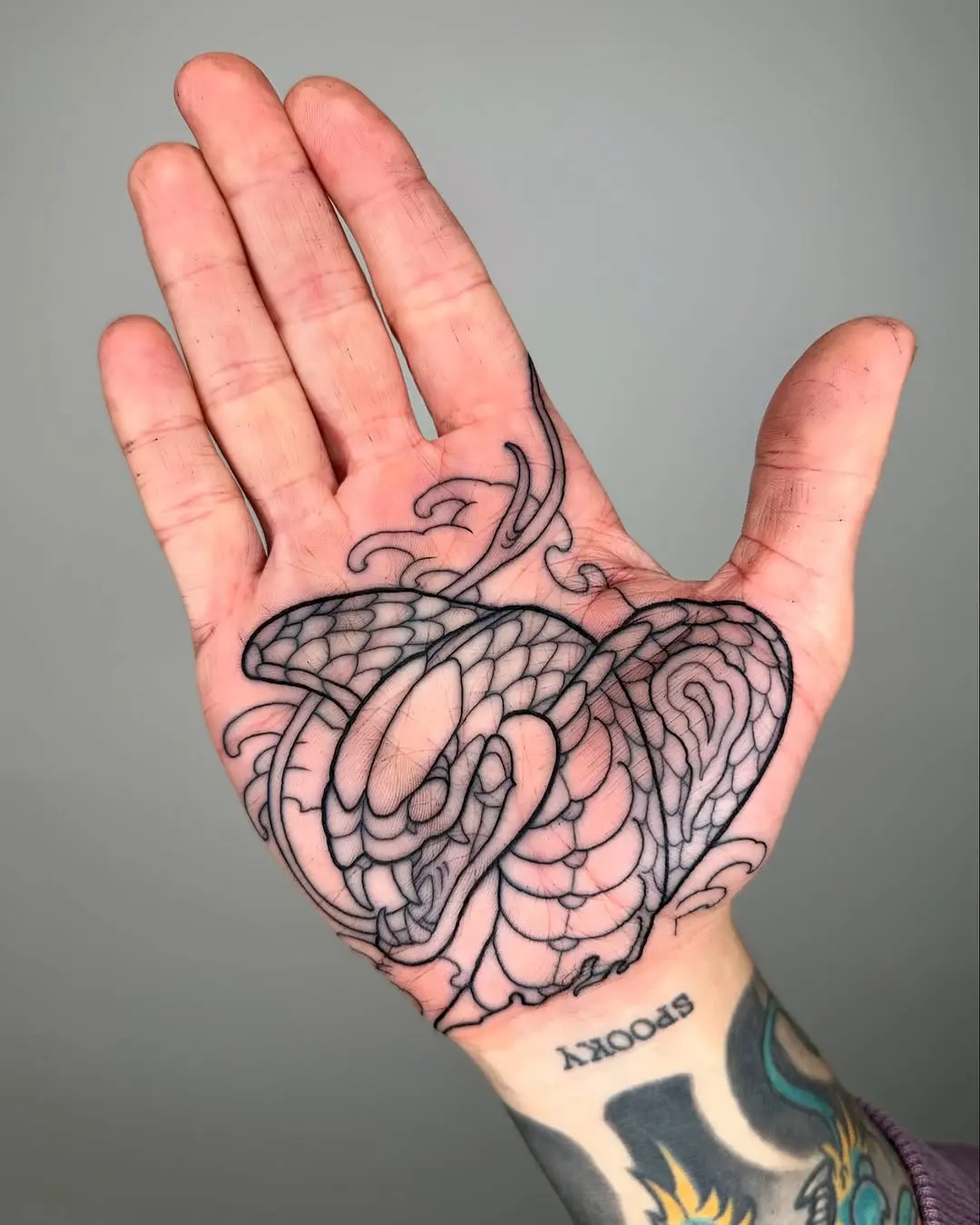 Intricate snake design on palm tattoo