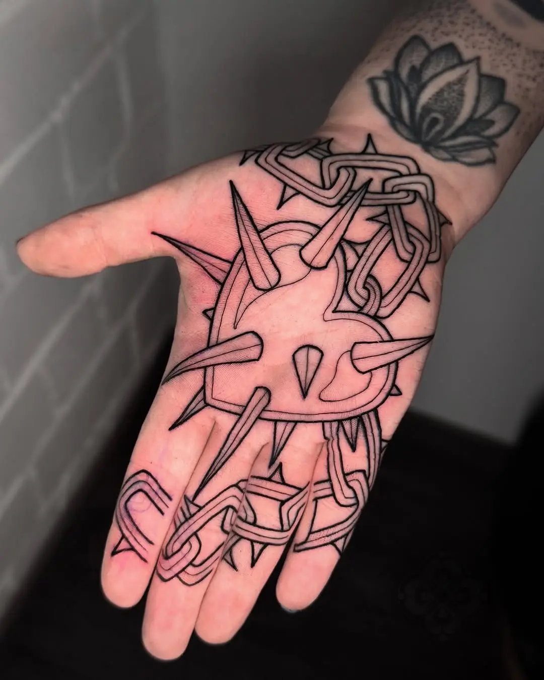 Edgy heart tattoo with chains and spikes
