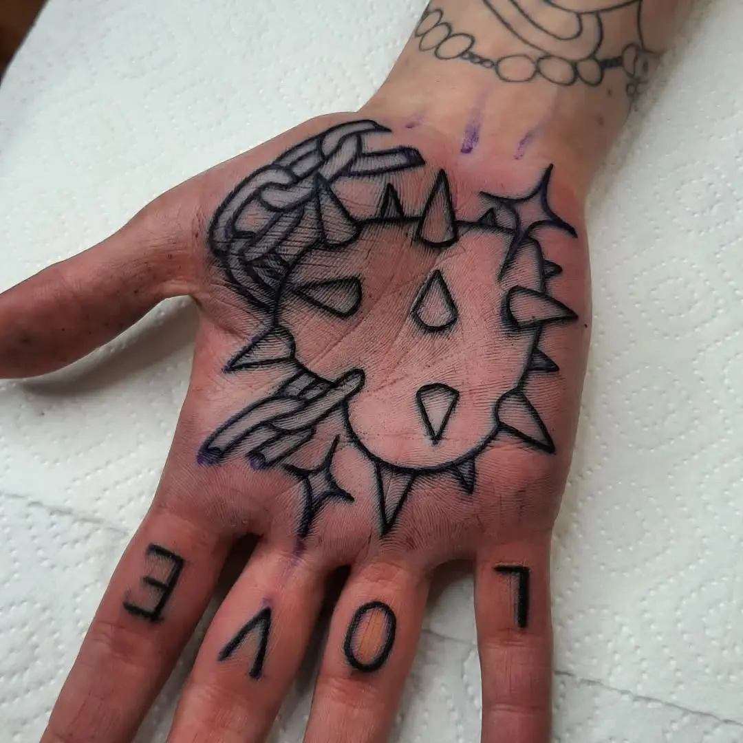 Bold spiked heart tattoo with love inscription