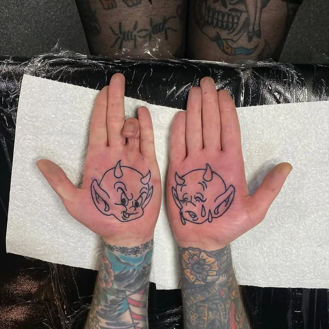 Playful devil designs on palm tattoos