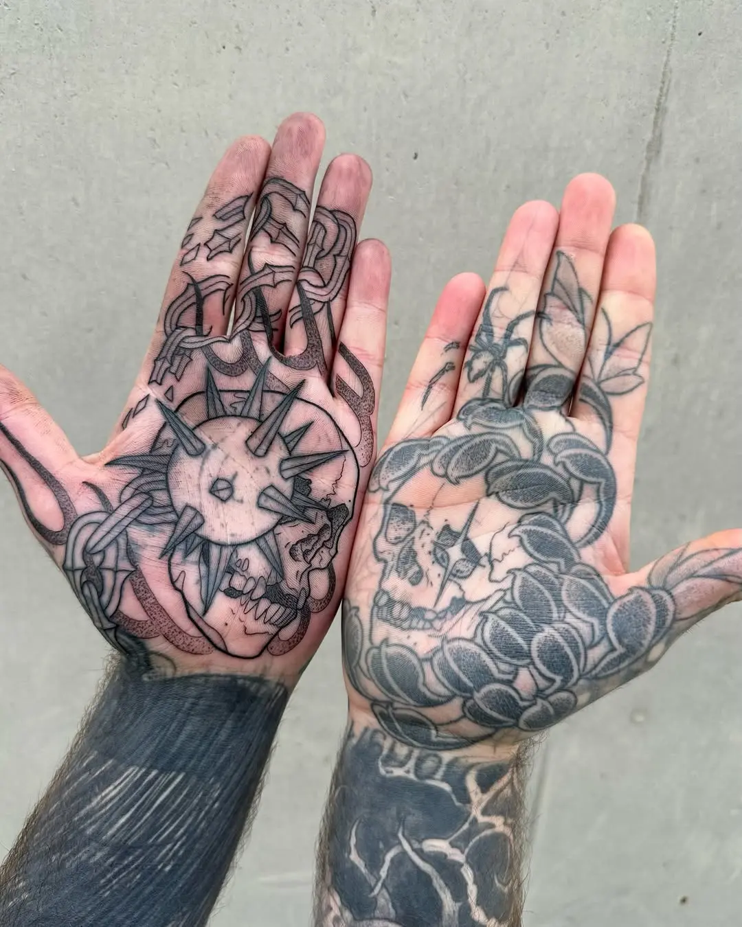 Intricate palm tattoos blending nature and skulls