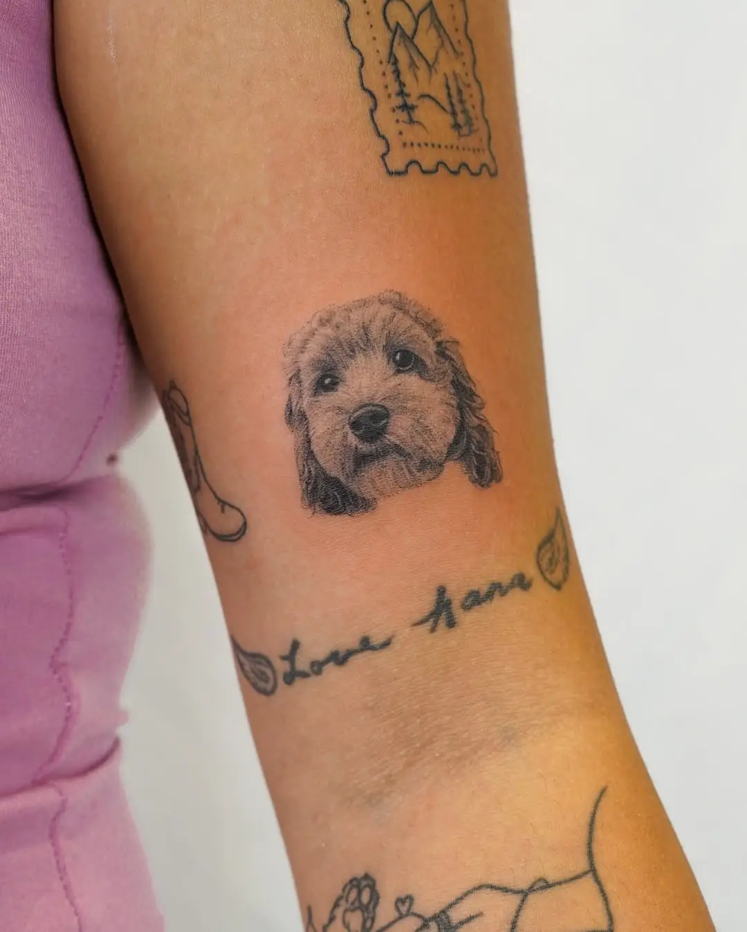 Adorable poodle face tattoo on the arm