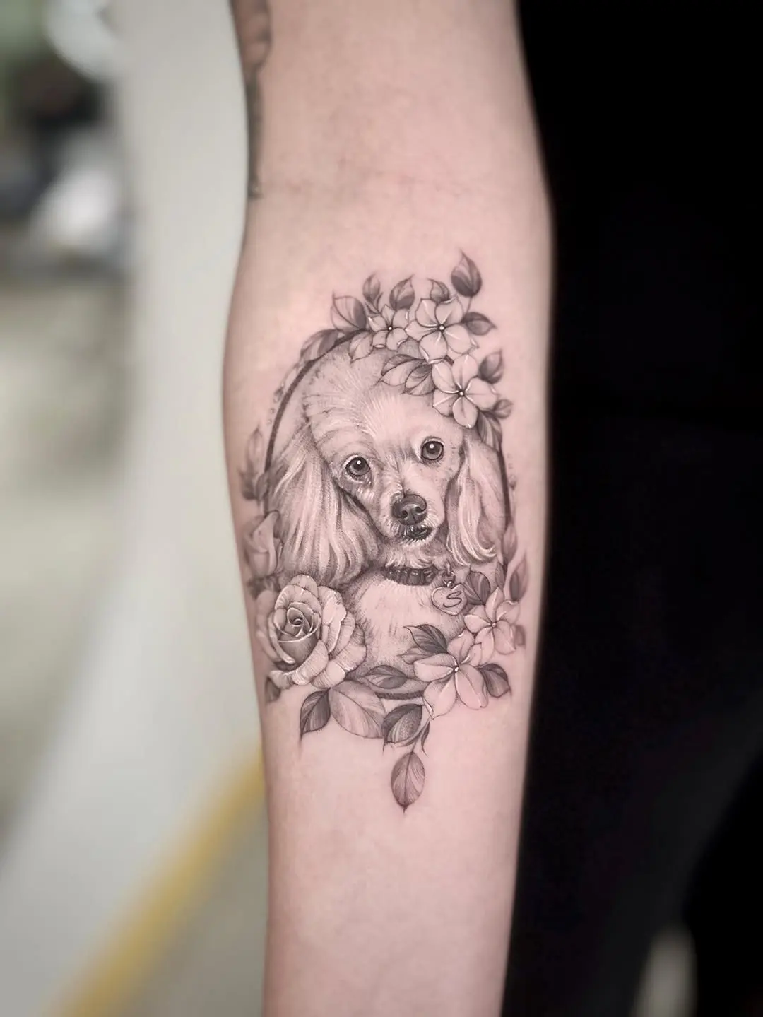 Elegant poodle tattoo with floral accents