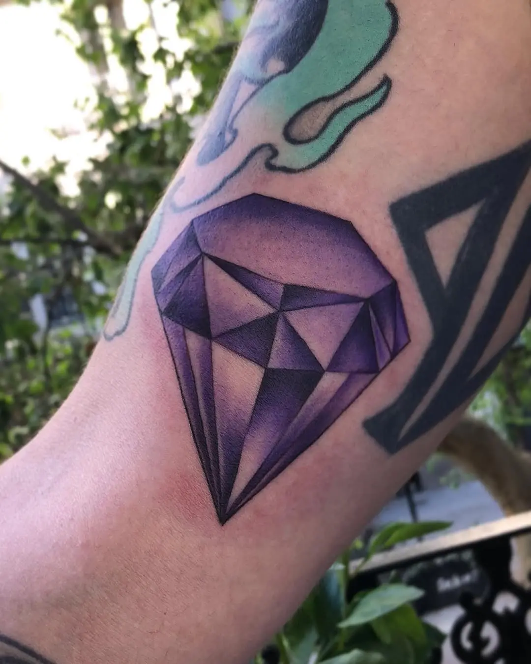 Stunning purple diamond tattoo on the arm