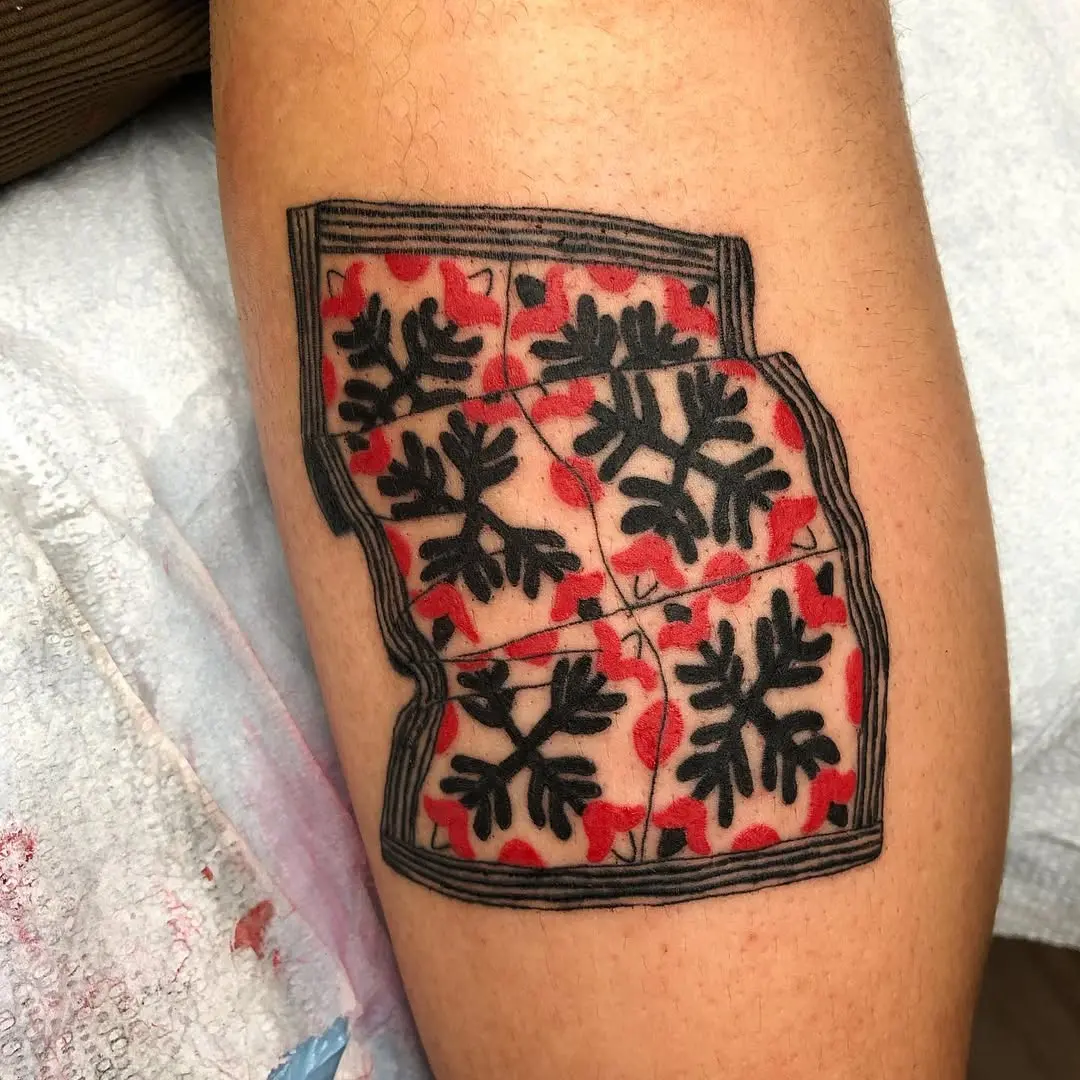 Vibrant quilt tattoo with floral patterns