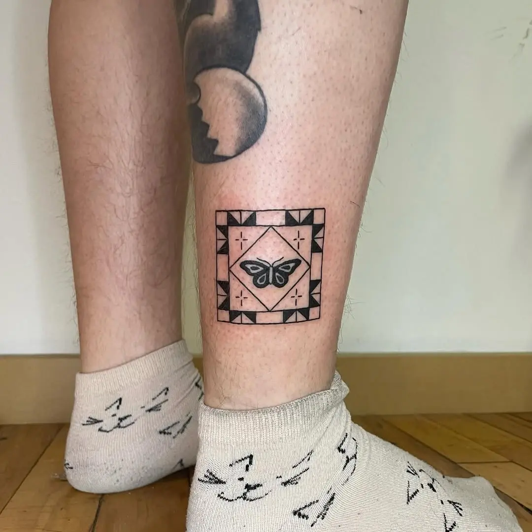 Intricate quilt tattoo featuring a butterfly design