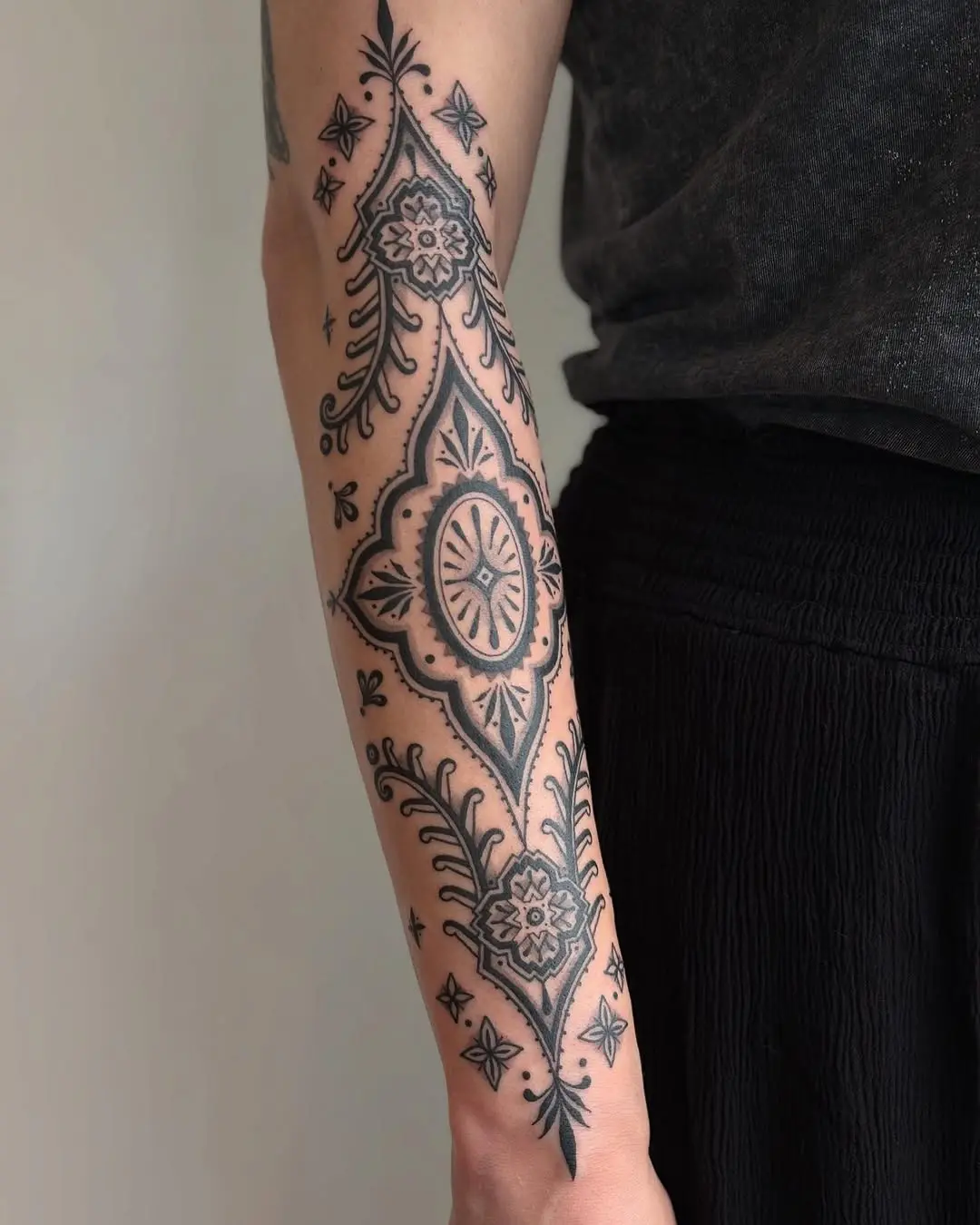 Intricate floral quilt tattoo on forearm