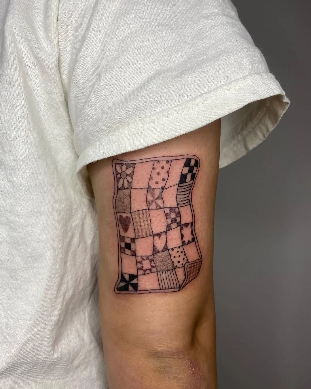 Colorful patchwork quilt tattoo on the arm