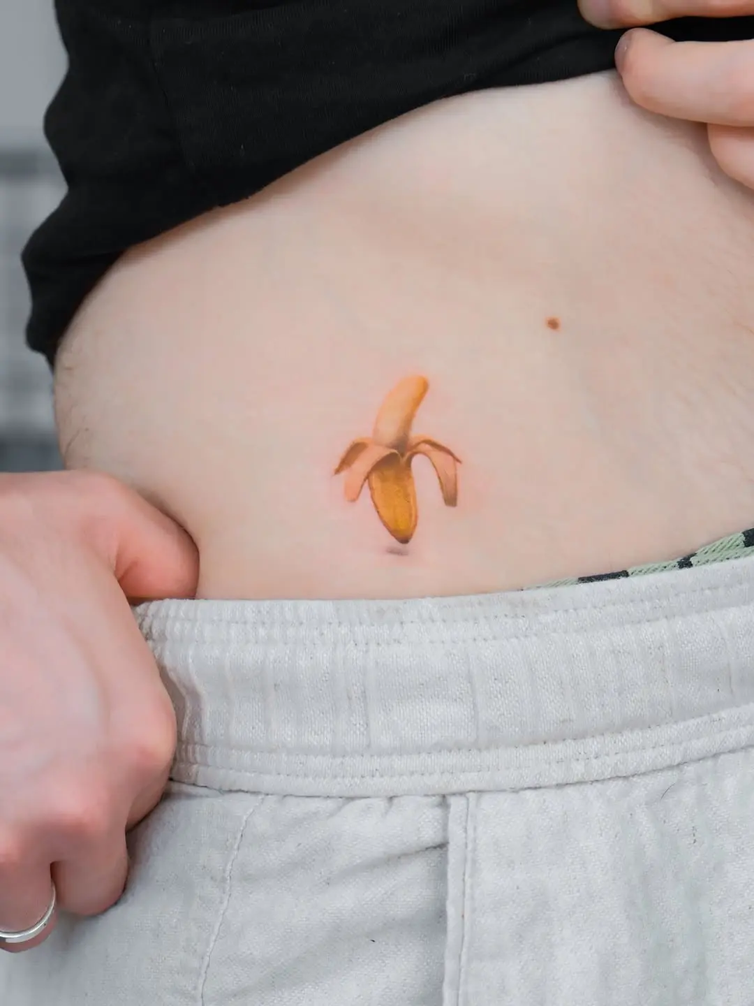 Colorful banana tattoo on side of abdomen
