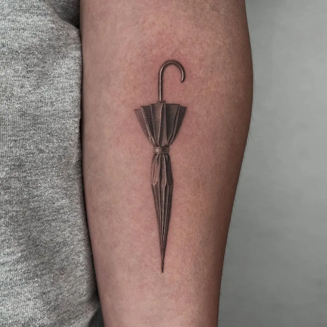 Elegant realistic umbrella tattoo on forearm