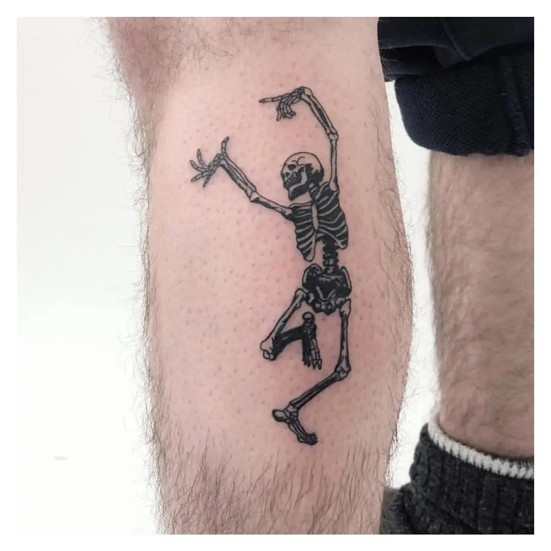Whimsical skeleton dancing tattoo on leg