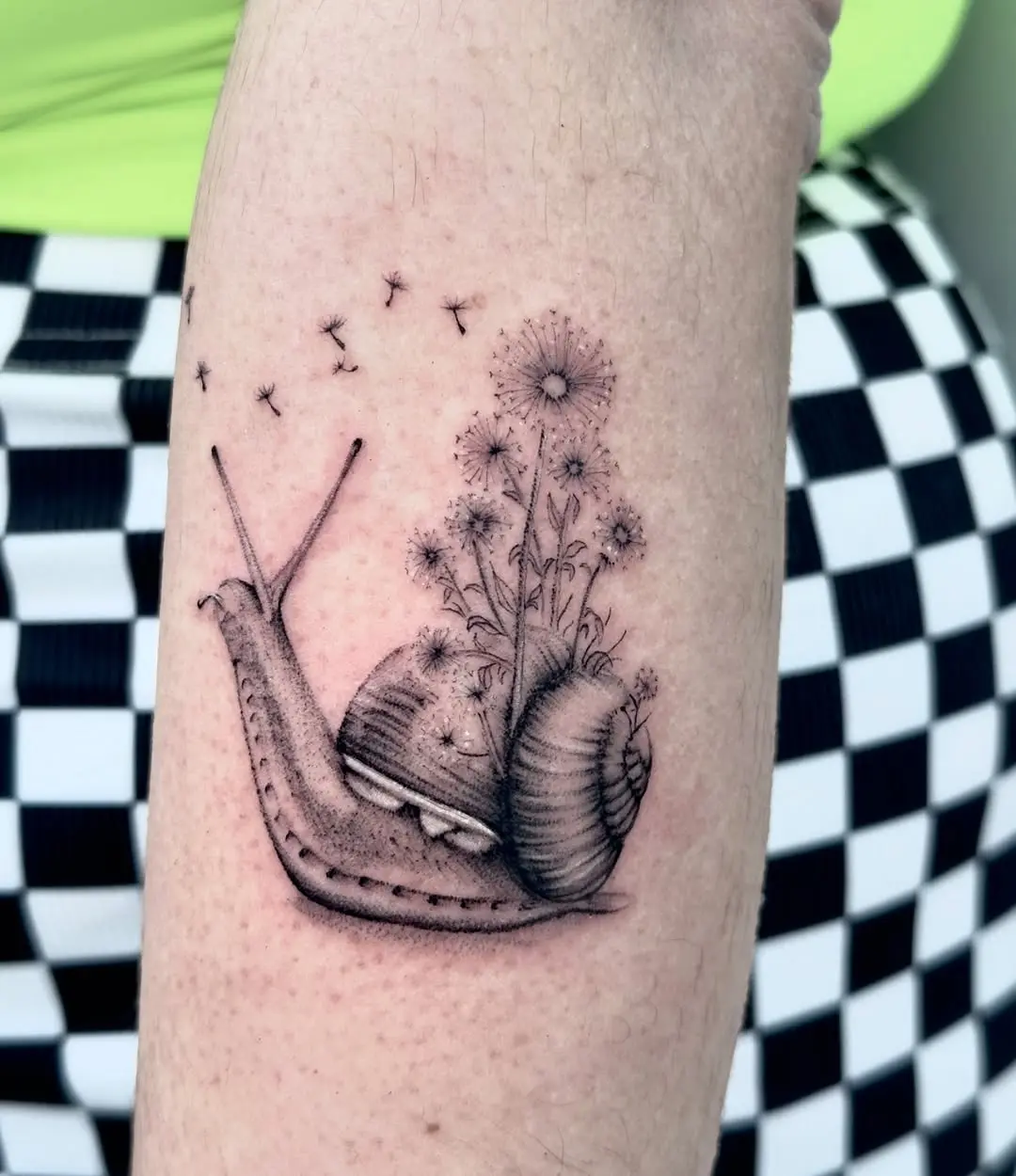 Charming snail tattoo with dandelions design