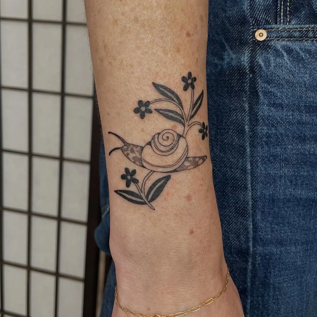 Charming snail tattoo with floral elements