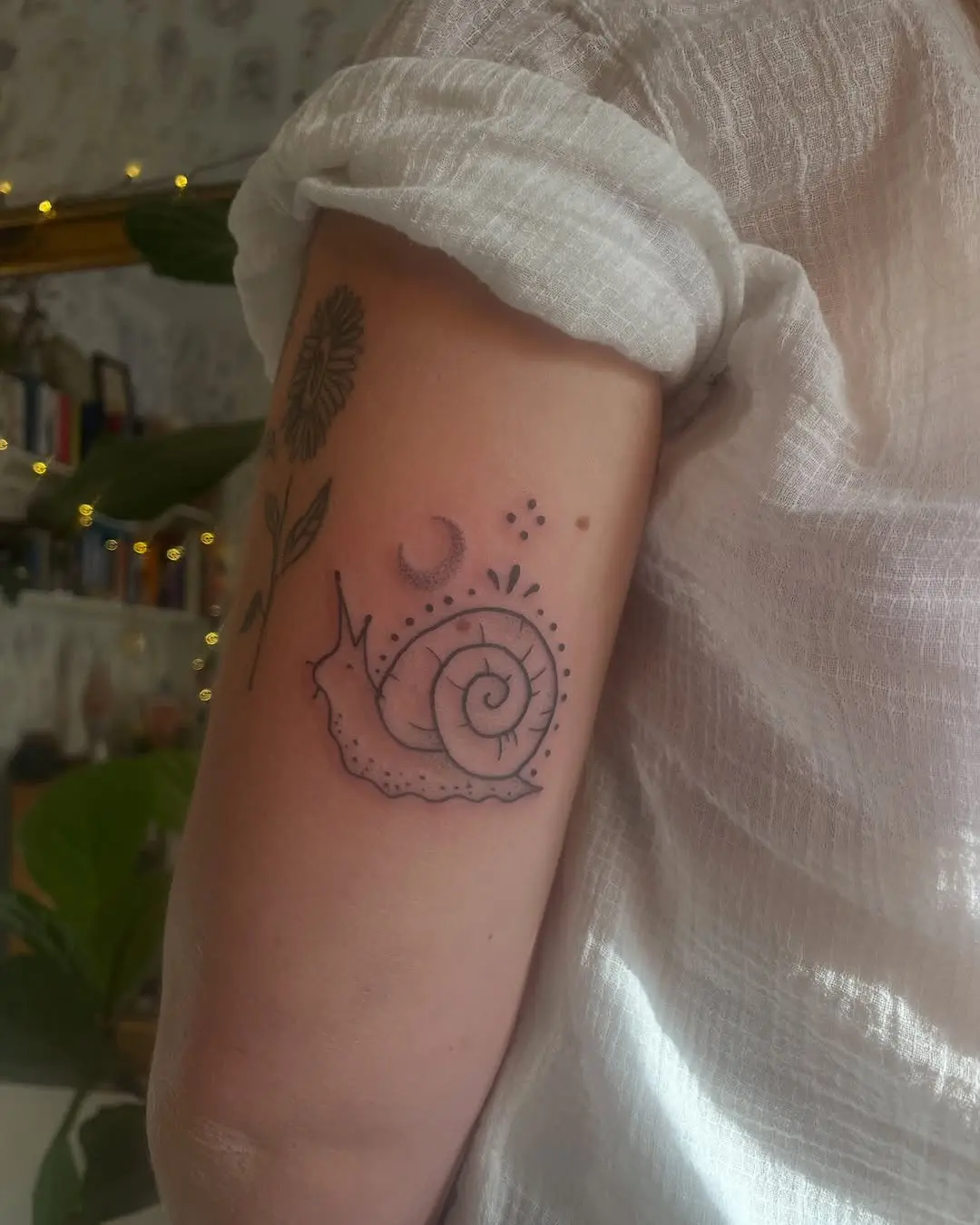Charming snail tattoo with floral accents