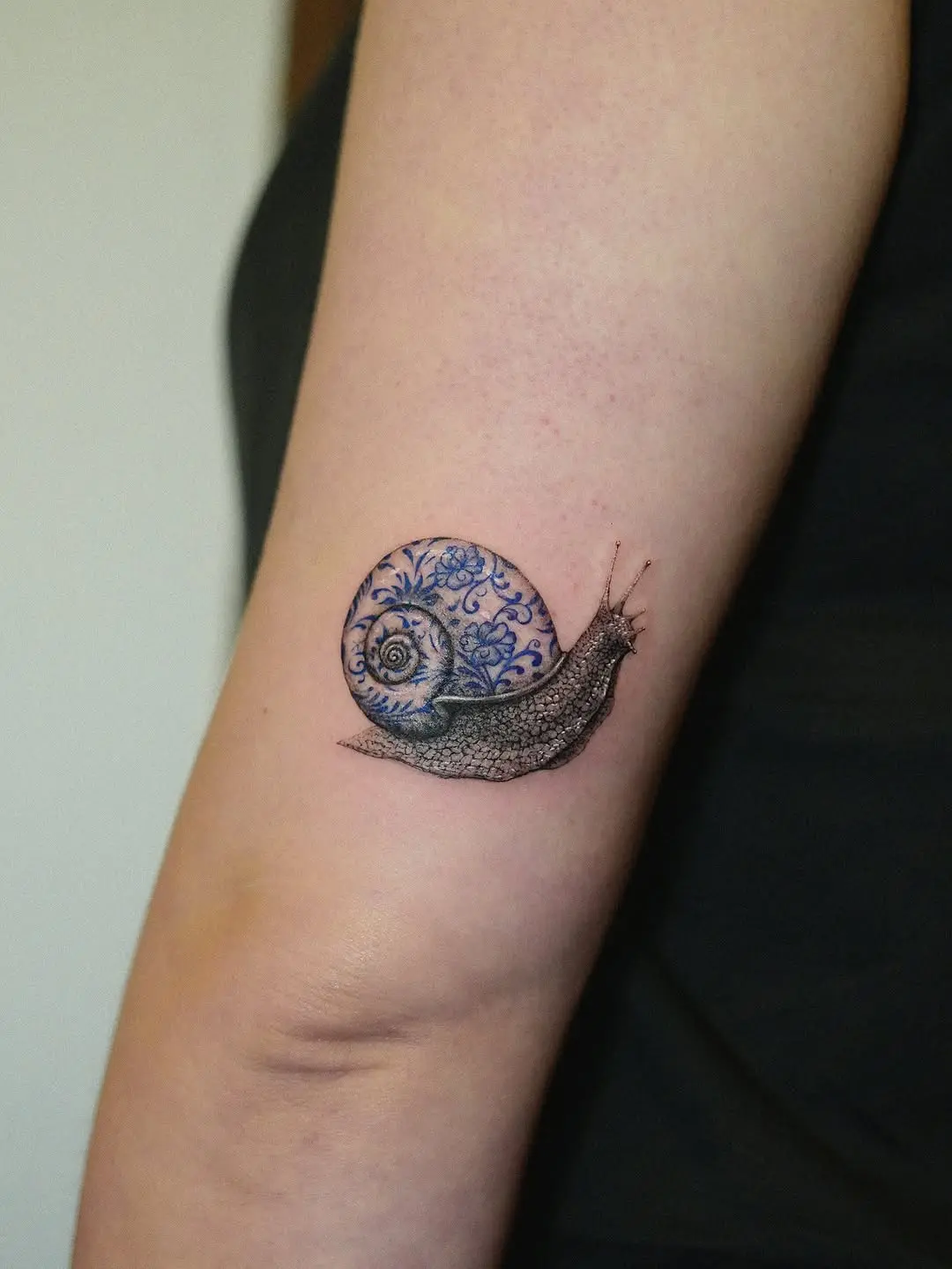 Intricate Snail Tattoo with Blue Floral Design