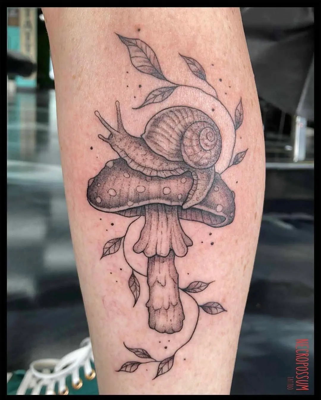 Charming snail on a whimsical mushroom tattoo