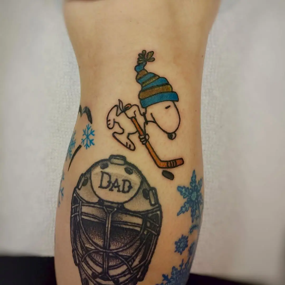 Snoopy skating on ice with hockey stick tattoo