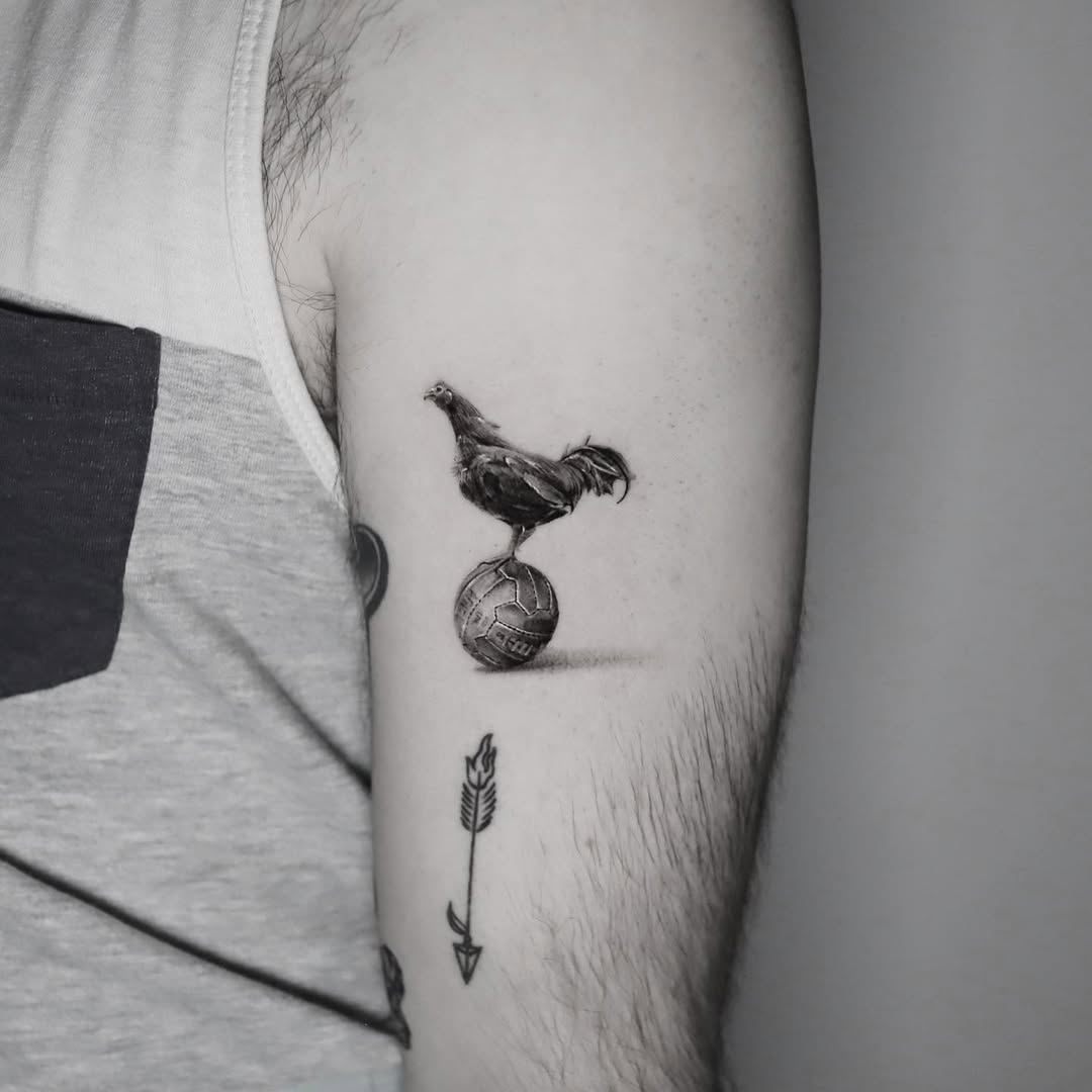 Whimsical chicken balancing on a soccer ball tattoo