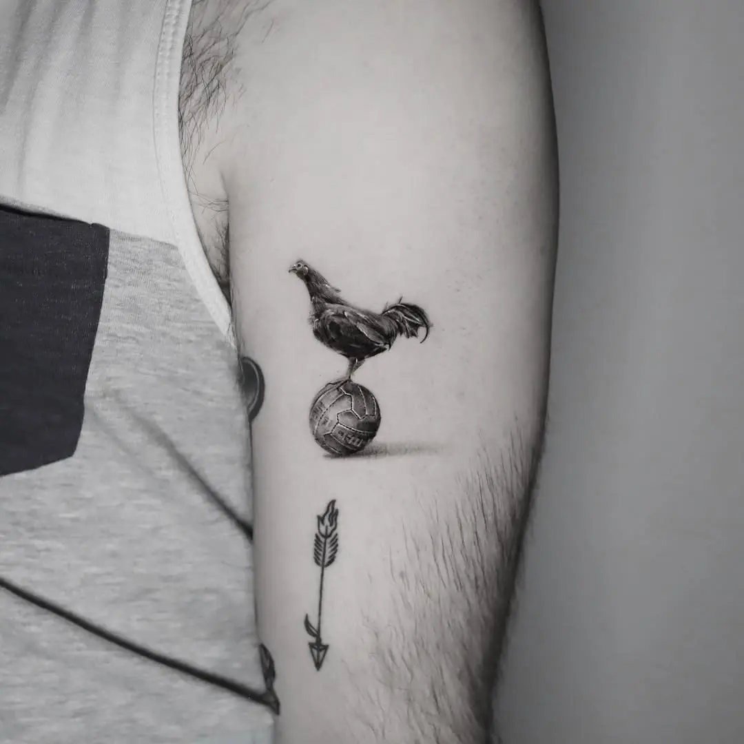 Whimsical chicken balancing on a soccer ball tattoo