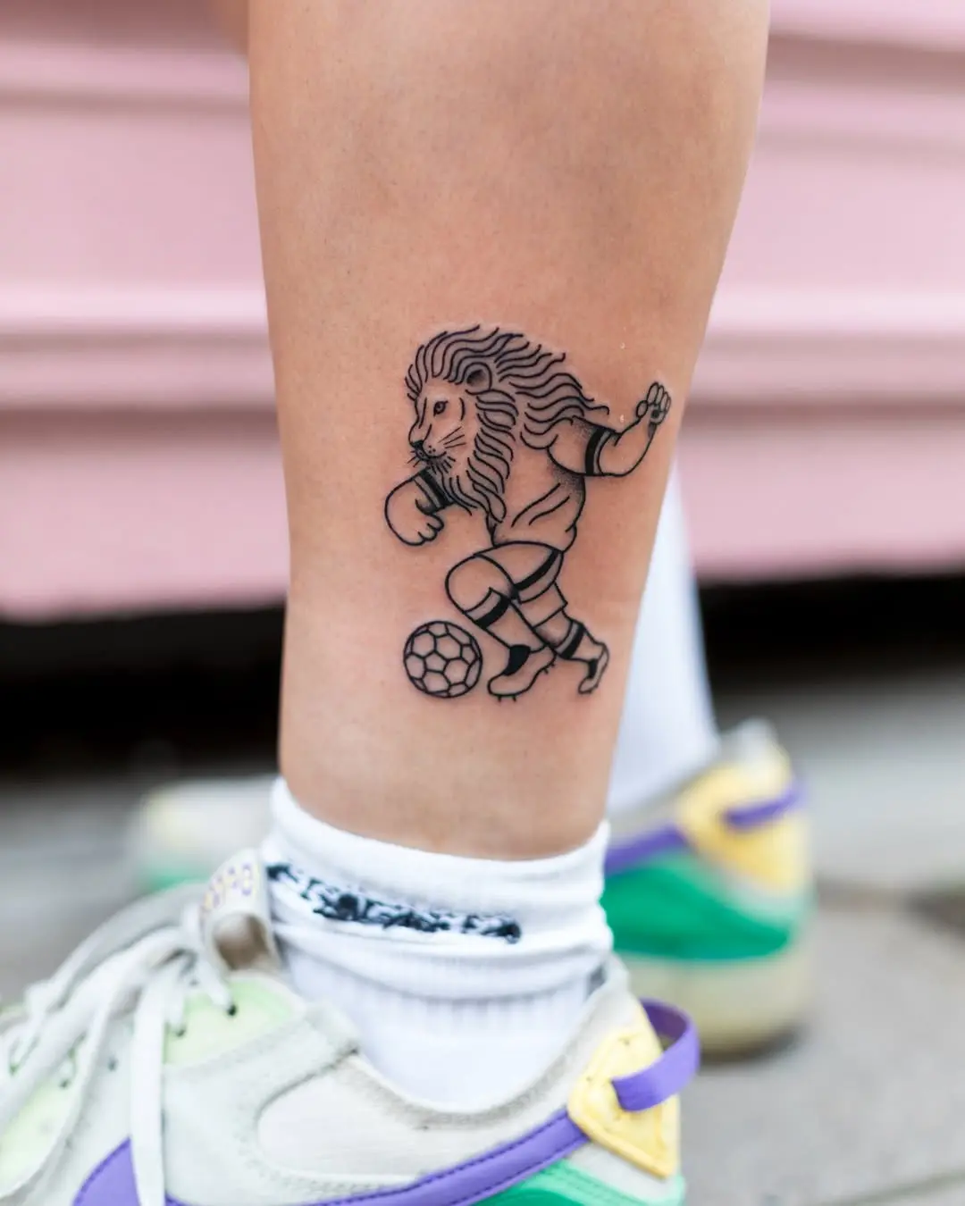 Dynamic lion tattoo showcasing soccer skills