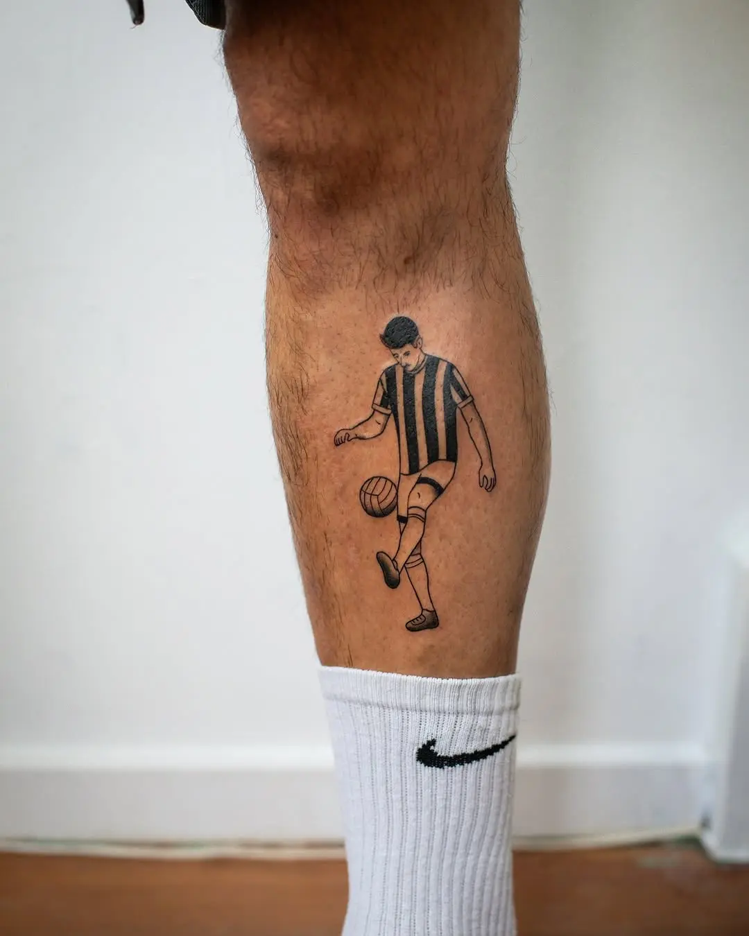 Stylized soccer player tattoo on the leg