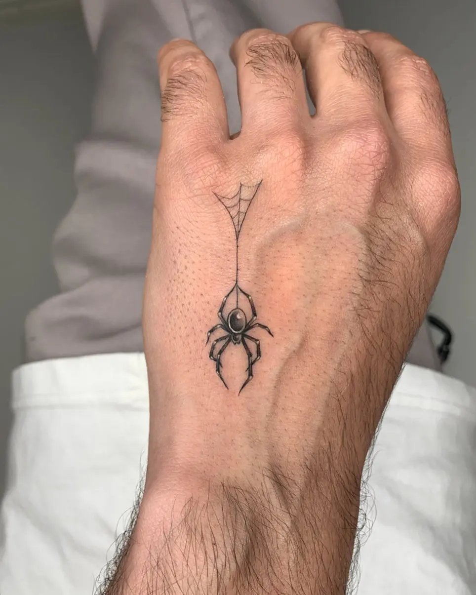 Minimalist spider tattoo on the hand