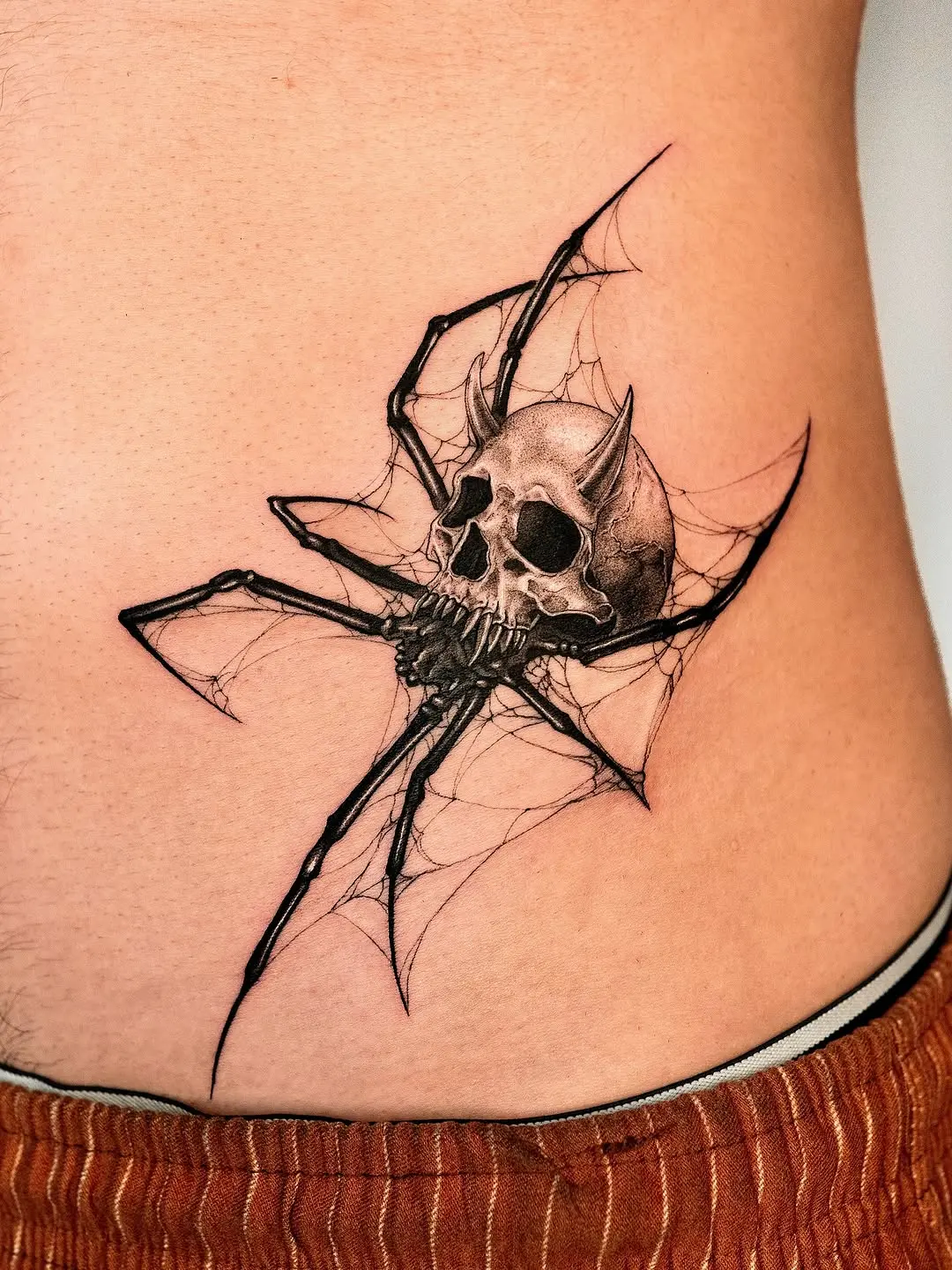 Striking spider skull tattoo with web details