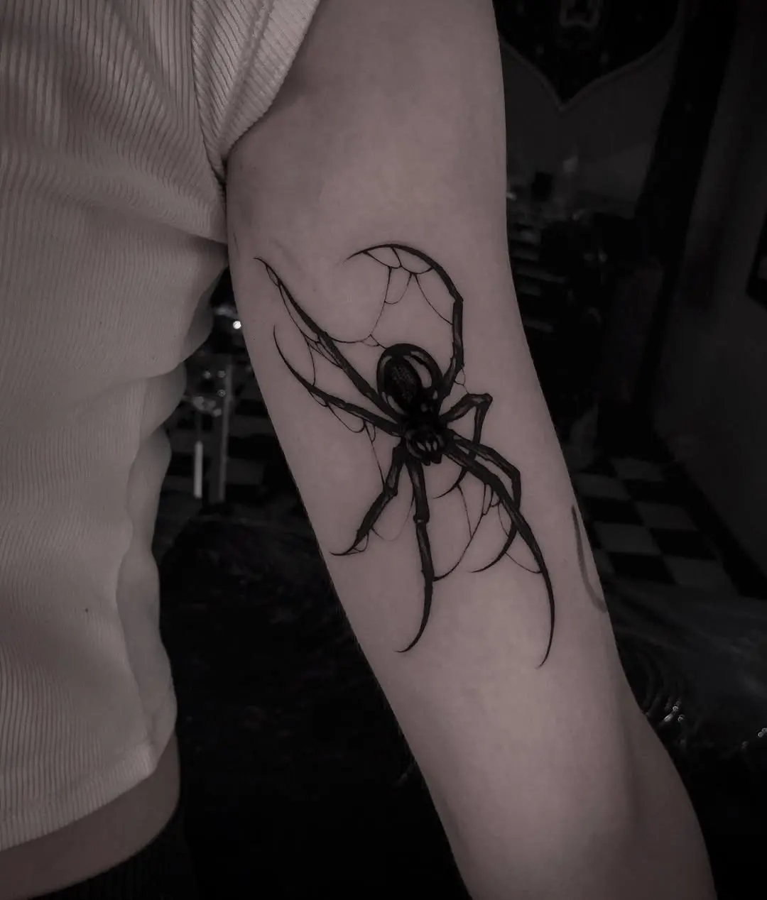 Intricate black spider tattoo with web details