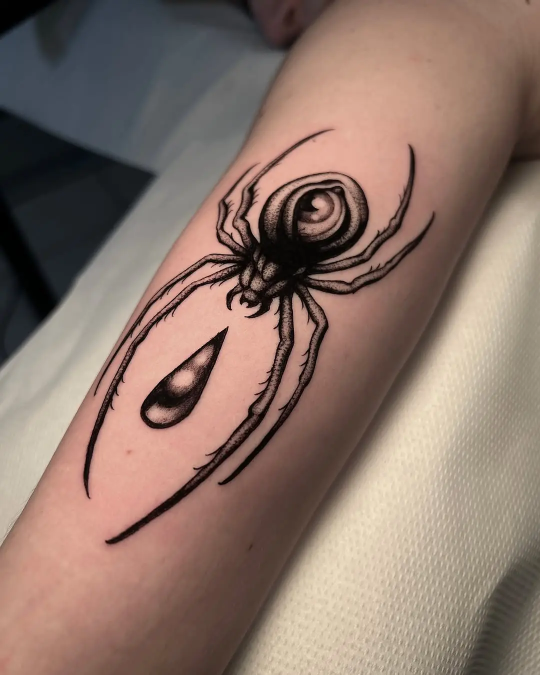 Elegant black line-art spider tattoo design