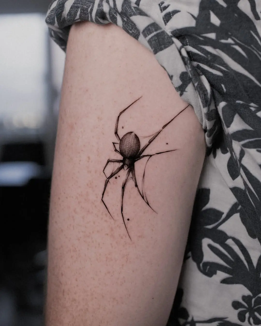 Intricate blackwork spider tattoo on arm