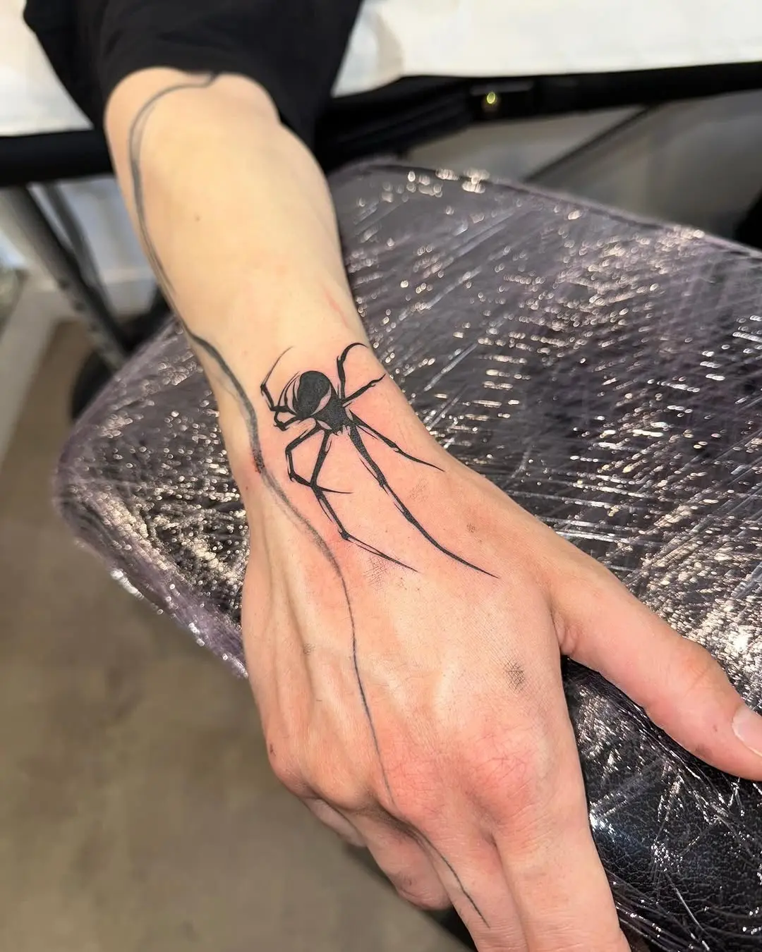Intricate spider tattoo on elegant hand