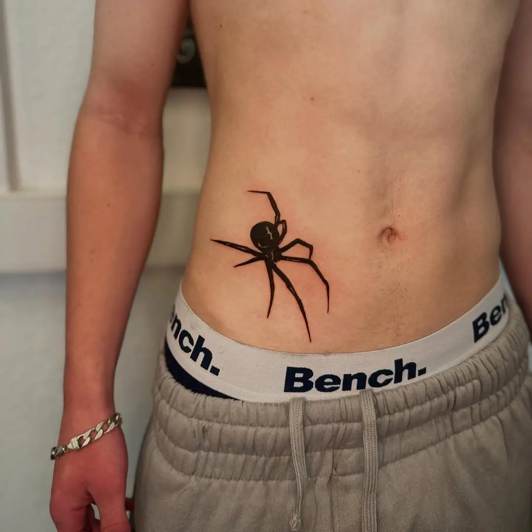 Striking black ink spider tattoo on abdomen