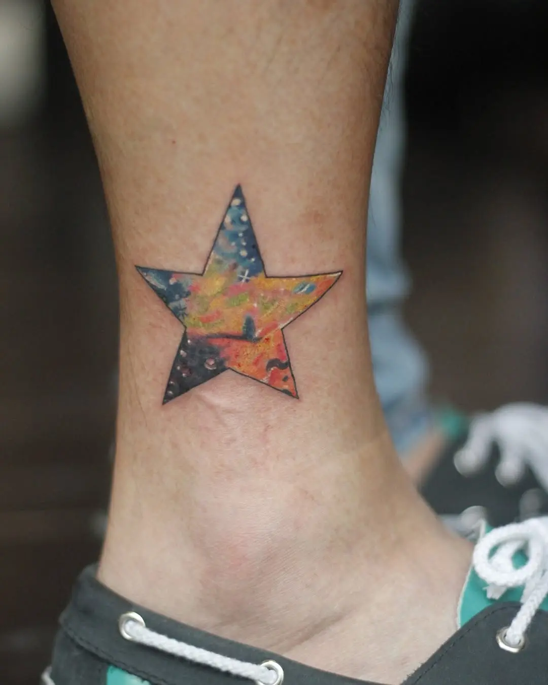 Colorful galaxy star tattoo on the ankle