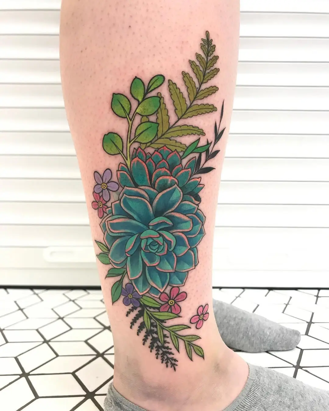 Stunning vibrant succulent tattoo on a leg