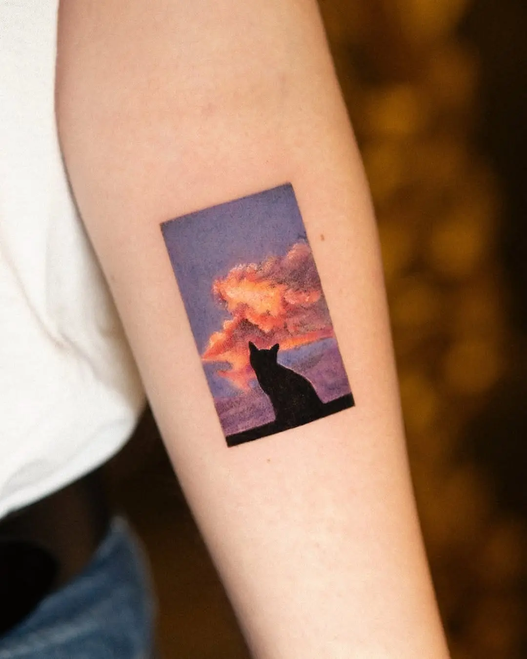 Serene sunrise silhouette of a cat tattoo