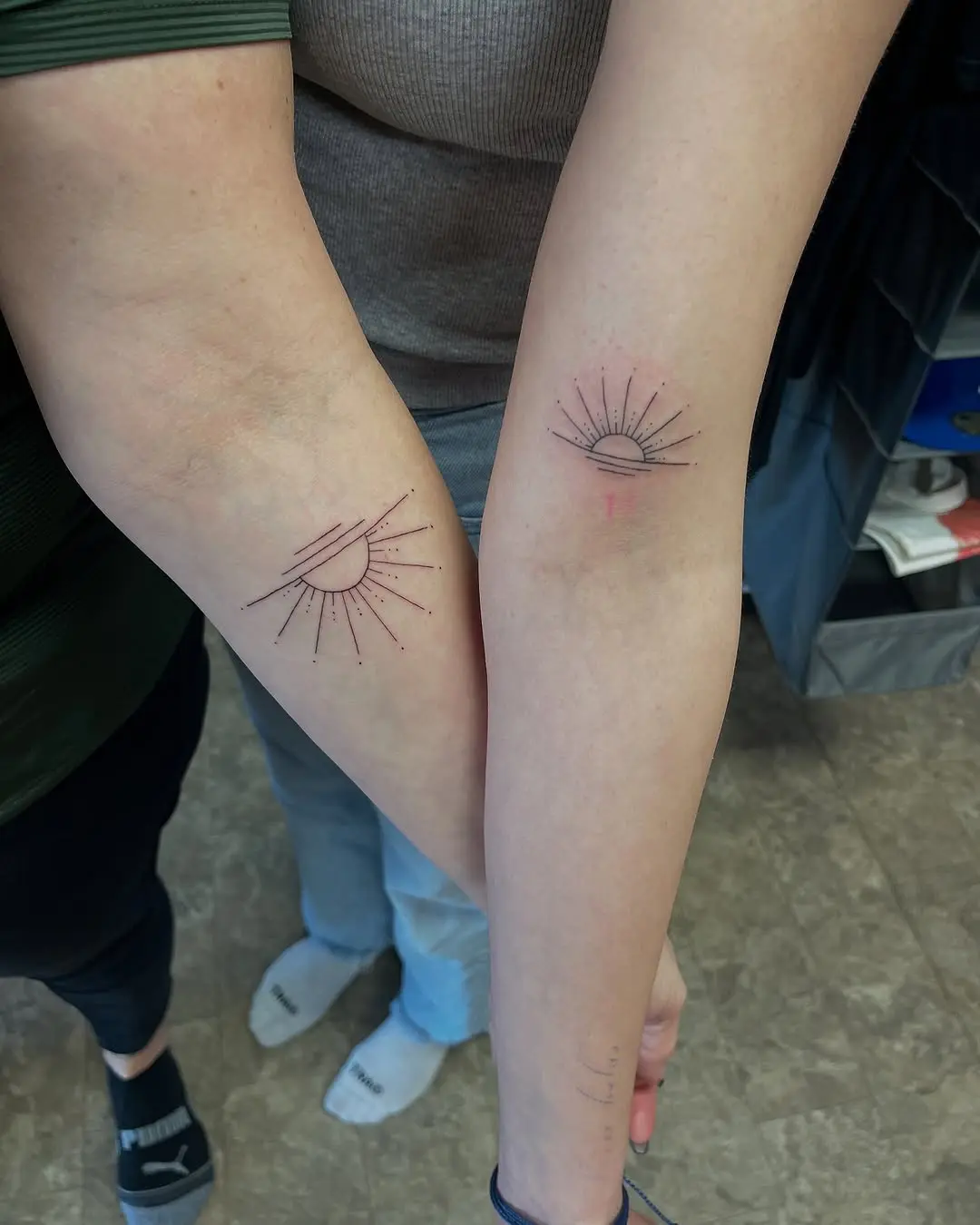 Symbolic sunrise tattoos on graceful arms