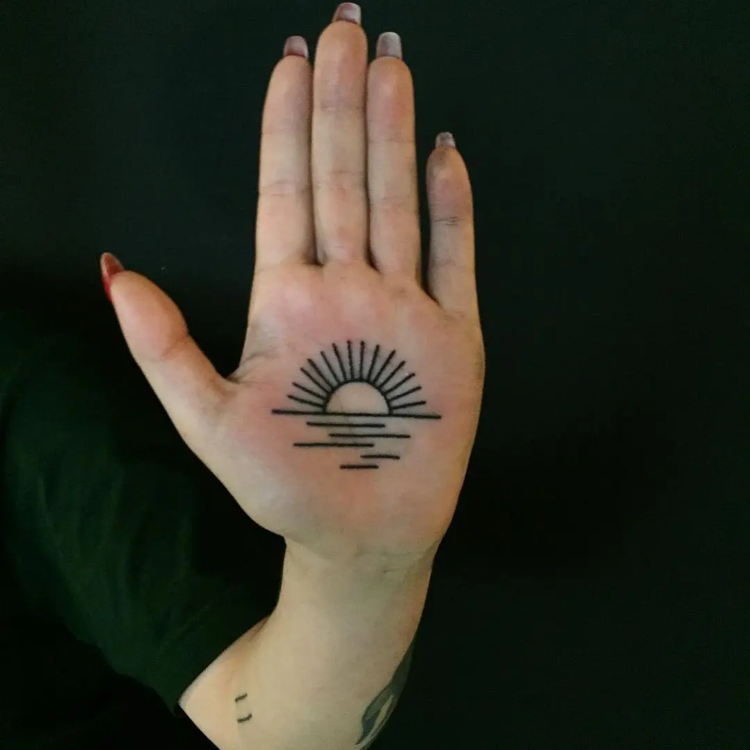 Minimalist sunrise tattoo on hand's palm